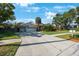 Home with well-manicured lawn, palm trees, and a spacious three car garage and wide driveway at 512 Crystal Grove Blvd, Lutz, FL 33548