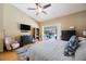 Large bedroom featuring ceiling fan, pool view, dresser, tv, and wooden floors at 512 Crystal Grove Blvd, Lutz, FL 33548