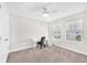 Bedroom features neutral carpet, a ceiling fan, and a work area with a modern desk and chair at 5351 Bridge St # 16, Tampa, FL 33611
