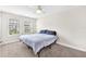 Simple bedroom with carpet, ceiling fan, and windows providing natural light, furnished with a basic bed frame at 5351 Bridge St # 16, Tampa, FL 33611