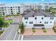Aerial view of a three-story townhouse featuring white exterior and a community entrance with a gate at 5351 Bridge St # 16, Tampa, FL 33611