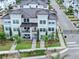 Aerial view of a three-story townhome featuring white exterior and lush landscaping at 5351 Bridge St # 16, Tampa, FL 33611