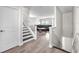 Inviting entryway featuring staircase with white railing, leading to an open-concept living room, and tile floors at 5351 Bridge St # 16, Tampa, FL 33611