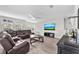 Comfortable living room featuring modern decor, large leather sofa, wood floors, and large windows with blinds at 5351 Bridge St # 16, Tampa, FL 33611