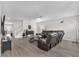 Open living room features a comfortable leather sofa, a modern ceiling fan, and wood-look tile flooring at 5351 Bridge St # 16, Tampa, FL 33611