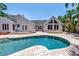 Beautiful backyard showcases a sparkling pool, brick patio, and a lush, tropical landscape at 555 21St Ne Ave, St Petersburg, FL 33704
