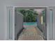 View of the backyard pool through open French doors and paved walkway at 555 21St Ne Ave, St Petersburg, FL 33704