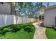 A manicured backyard features brick pavers transitioning to green turf, and a view of the screened patio at 555 21St Ne Ave, St Petersburg, FL 33704