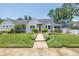 Charming single-story home featuring a meticulously landscaped front yard and welcoming brick walkway at 555 21St Ne Ave, St Petersburg, FL 33704