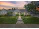 Charming single-story home featuring a meticulously landscaped front yard and welcoming brick walkway at 555 21St Ne Ave, St Petersburg, FL 33704