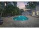 A serene pool with brick surround is complimented by lush tropical landscaping and a cozy seating area at 555 21St Ne Ave, St Petersburg, FL 33704