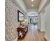 Inviting hallway with decorative wallpaper, wood flooring, and view into the living area at 5804 Terncrest Dr, Lithia, FL 33547