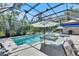 Sparkling screened pool and spa with shaded seating and lush tropical landscaping at 5804 Terncrest Dr, Lithia, FL 33547