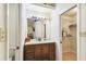 Well-lit bathroom featuring vanity with sink, mirror, and access to a walk-in closet for extra storage at 5908 Mohr Rd, Tampa, FL 33615