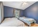 This cozy bedroom features dual beds, a ceiling fan, and a window with natural light at 5908 Mohr Rd, Tampa, FL 33615
