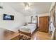 Comfortable bedroom with hardwood floors, a ceiling fan, and a window for natural light at 5908 Mohr Rd, Tampa, FL 33615