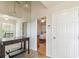 Spacious hallway with a view into a bedroom, a mirror, and a console table on top of the tile floor at 5908 Mohr Rd, Tampa, FL 33615