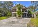 Inviting two-story home featuring dual balconies and a unique stilt foundation with landscaped yard at 5908 Mohr Rd, Tampa, FL 33615