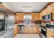 Well-equipped kitchen featuring stainless steel appliances and warm-toned wood cabinetry at 5908 Mohr Rd, Tampa, FL 33615