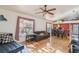 Sunlit living room with hardwood floors, a ceiling fan, and a view to the kitchen area at 5908 Mohr Rd, Tampa, FL 33615