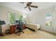 Bright bedroom featuring a twin bed, ceiling fan, carpeted floor, and two windows offering natural light at 6663 Bayou Grande Ne Blvd, St Petersburg, FL 33702