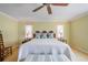 Comfortable bedroom features a white bedspread, decorative pillows and fan overhead at 6663 Bayou Grande Ne Blvd, St Petersburg, FL 33702