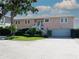 Charming two-story home with landscaped yard, featuring a staircase leading to the front door and a driveway at 6663 Bayou Grande Ne Blvd, St Petersburg, FL 33702