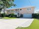 Charming two-story home with landscaped yard, featuring a staircase leading to the front door and a driveway at 6663 Bayou Grande Ne Blvd, St Petersburg, FL 33702
