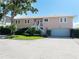 Charming two-story home with landscaped yard, featuring a staircase leading to the front door and a driveway at 6663 Bayou Grande Ne Blvd, St Petersburg, FL 33702