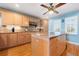Beautiful kitchen featuring an island, natural wood cabinets, granite countertops, and a ceiling fan at 6663 Bayou Grande Ne Blvd, St Petersburg, FL 33702
