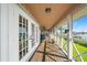 Covered porch with wooden floors, white railings, and beautiful water views from multiple vantage points at 6663 Bayou Grande Ne Blvd, St Petersburg, FL 33702