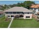 Rear exterior showing garages below an expansive covered porch and lush green lawn at 6663 Bayou Grande Ne Blvd, St Petersburg, FL 33702