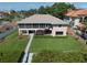 Rear exterior showing the stairs to an expansive covered porch and lush green lawn at 6663 Bayou Grande Ne Blvd, St Petersburg, FL 33702