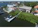 Rear exterior featuring lush landscaping, a private dock, and direct water access at 6663 Bayou Grande Ne Blvd, St Petersburg, FL 33702