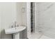 Beautiful bathroom with pedestal sink, marble-look tiled shower, and accent tiles adding an elegant design element at 6707 Josie Dr, Seffner, FL 33584