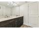 Bathroom with a dark wood vanity, double sinks, and a large mirror at 6707 Josie Dr, Seffner, FL 33584