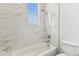 Beautiful bathroom with marble-look tiles, shower head, and a window providing natural light and ventilation at 6707 Josie Dr, Seffner, FL 33584