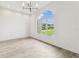 Bright dining room featuring wood-look tile floors, modern light fixture and a large arched window with a beautiful view at 6707 Josie Dr, Seffner, FL 33584