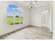 Bright dining room featuring wood-look tile floors, modern light fixture and a large arched window with a beautiful view at 6707 Josie Dr, Seffner, FL 33584