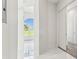 Hallway featuring light tile flooring and a view of a large window in a bedroom at 6707 Josie Dr, Seffner, FL 33584