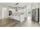 Bright kitchen features a large center island, stainless steel appliances, and wood-look floors at 6707 Josie Dr, Seffner, FL 33584