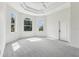 Spacious main bedroom with tray ceiling, three large windows and carpeted flooring at 6707 Josie Dr, Seffner, FL 33584