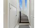 Bright staircase featuring white walls, black stairs, and a large window showcasing the blue sky at 6707 Josie Dr, Seffner, FL 33584