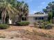 Single story home with a lawn featuring mature palms and a traditional, symmetrical facade at 7519 Kensico Dr, Port Richey, FL 34668