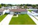 Aerial view of a grey house featuring a manicured lawn, new driveway and blue front door at 7909 Woodgrove Cir, Tampa, FL 33615