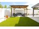 Inviting backyard featuring a pergola with comfortable seating and artificial turf at 7909 Woodgrove Cir, Tampa, FL 33615