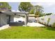 View of backyard featuring covered patio, pergola, and manicured grass at 7909 Woodgrove Cir, Tampa, FL 33615