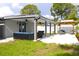 View of backyard featuring covered patio, pergola, and manicured lawn at 7909 Woodgrove Cir, Tampa, FL 33615