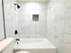 Close-up shot of the bathroom showing the tub and shower with white tiling at 7909 Woodgrove Cir, Tampa, FL 33615