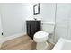 Bathroom featuring a dark vanity, mirror, toilet, and white trim at 7909 Woodgrove Cir, Tampa, FL 33615